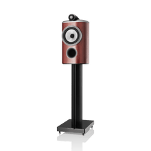 Speaker with wooden finish and black stand on a white background