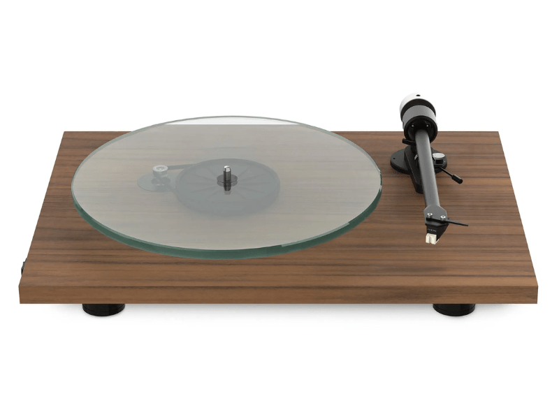 Wooden turntable with glass platter and metal tonearm on a white background