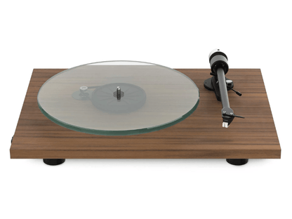 Wooden turntable with glass platter and metal tonearm on a white background