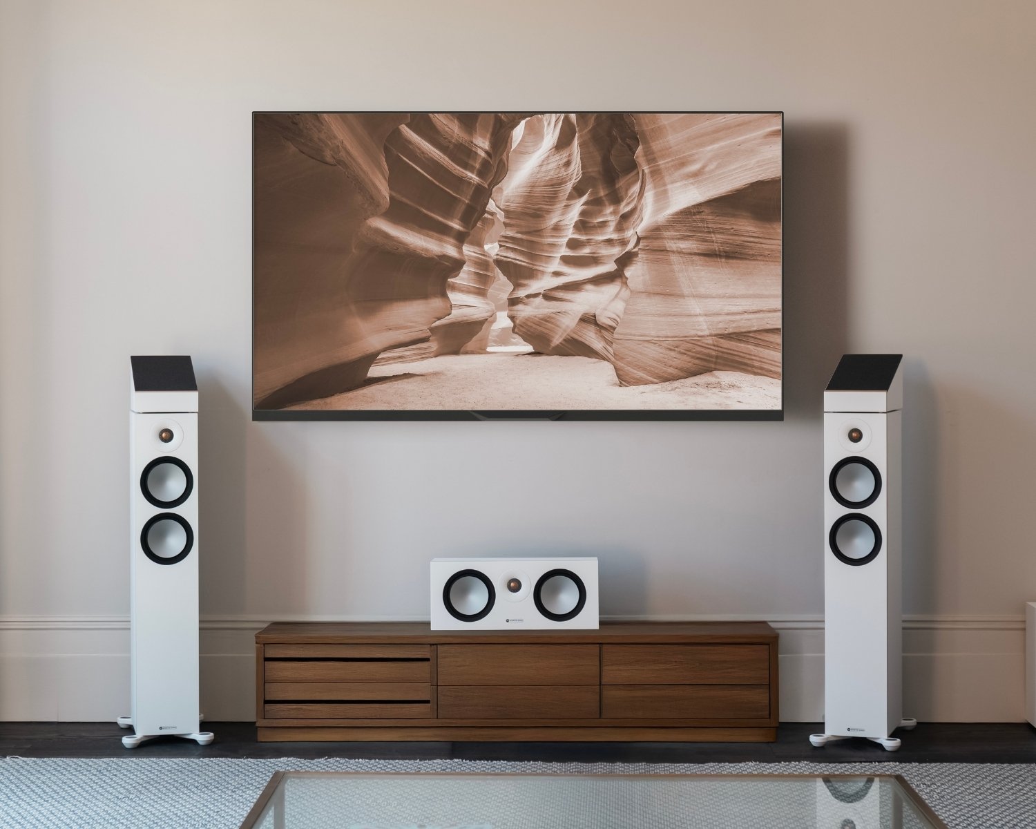 home theatre system with 2 tower speakers, 1 center speaker and a wall mounted tv