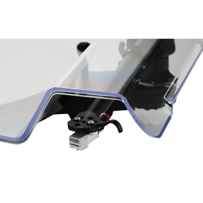 Close-up of the Rega Replay turntable’s Carbon moving magnet cartridge on a black tonearm headshell, seen beneath the curved edge of the clear acrylic dust cover.