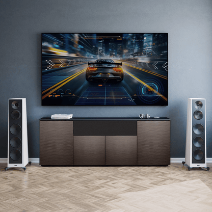 Modern living room with a large TV displaying a car racing game, flanked by two tall speakers.