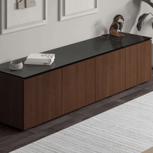 Wooden entertainment console with black top in a room setting