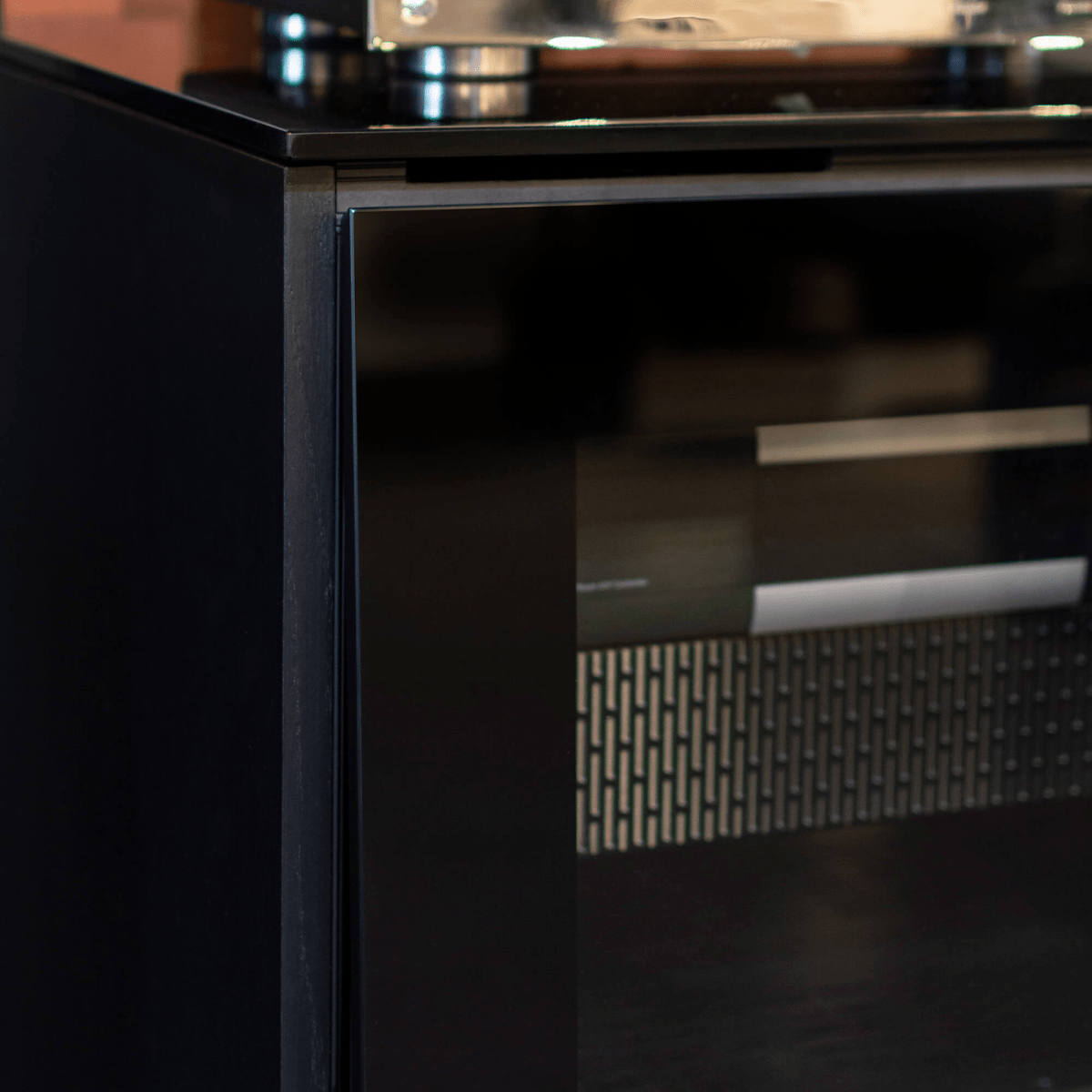 Close-up of a black appliance with metallic handle