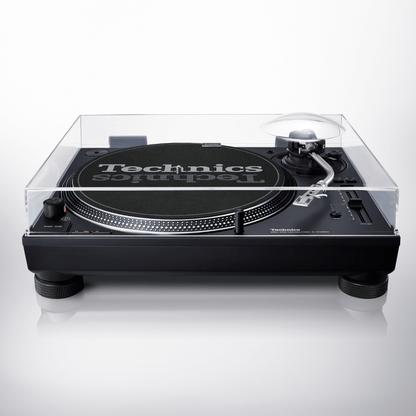 Front view of the Technics SL-1210MKX turntable with its clear dust cover closed over the platter, Technics slipmat and tonearm, on a light grey background.